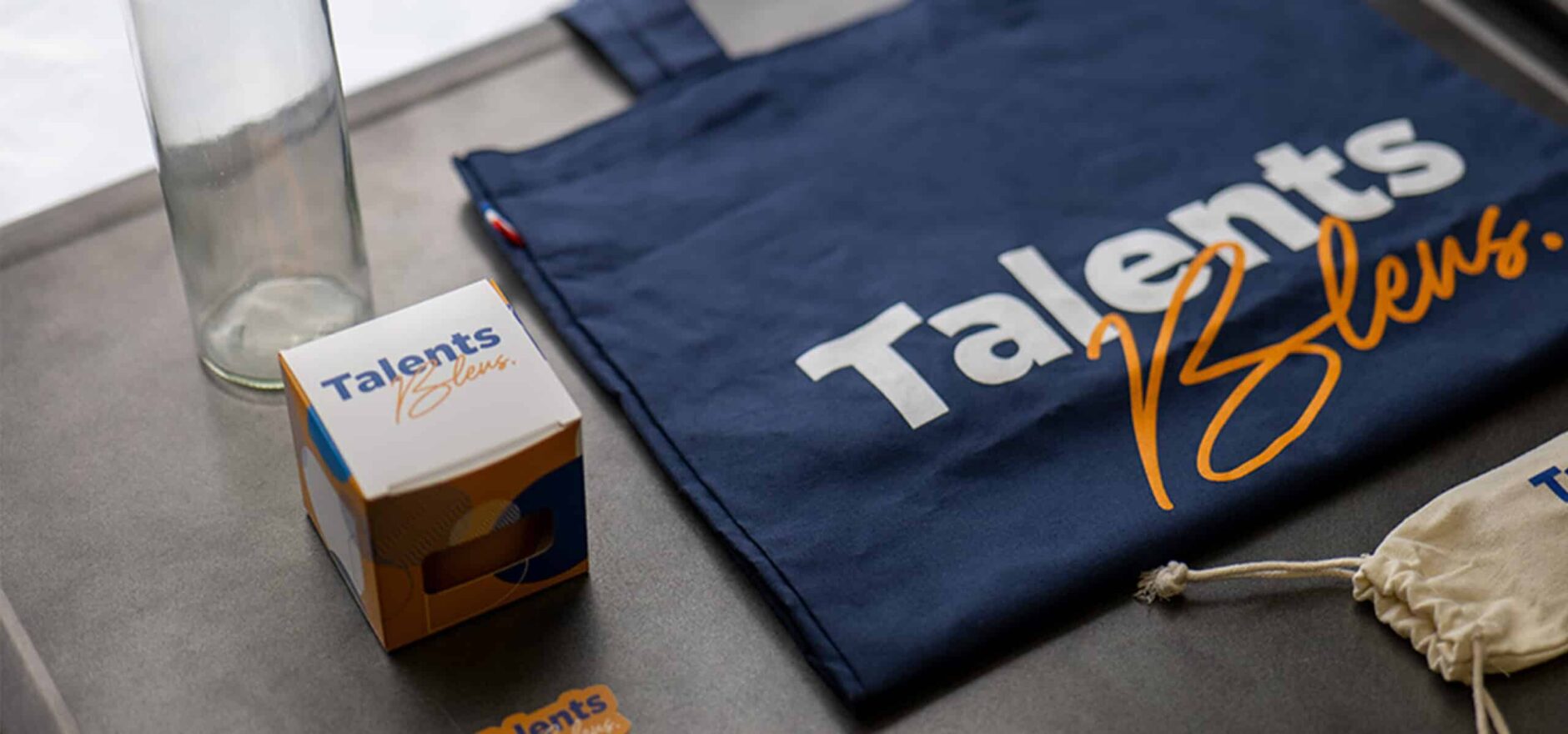 Le welcome pack du groupe Blue Soft avec une gourde, un tote bag, une plante, des couverts et un autocollant Talents Bleus