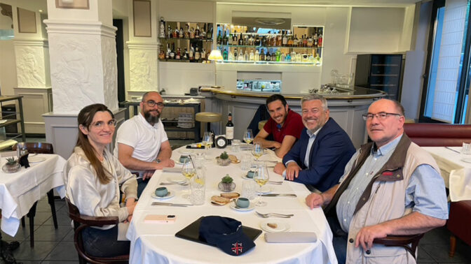 Cinq personnes autour d'une table qui s'apprêtent à déjeuner