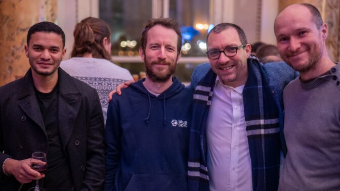 Des personnes se tenant par les épaules pour la photo, ils font partie de Blue Soft Engineering lors de la soirée de fin d'année de Blue Soft