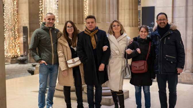 Plusieurs personnes qui se tiennent par les bras pour la photo