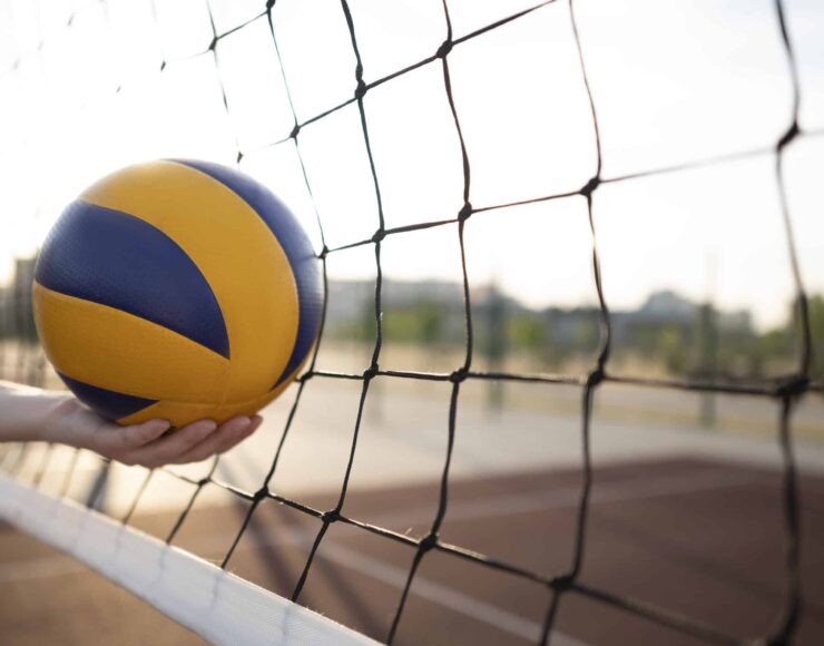 Un ballon de volleyball qui est dans un filet pour illustrer l'Association Chênois Genève Volleyball soutenu par Blue Soft dans le cadre du Projet Indigo