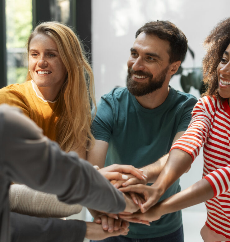 Des personnes se réunissant et mettant leurs mains au milieu pour illustrer les associations qui ont été soutenue dans le cadre du Projet Indigo Projet Indigo dans le cadre des engagements RSE de Blue Soft et de son Courant Bleu